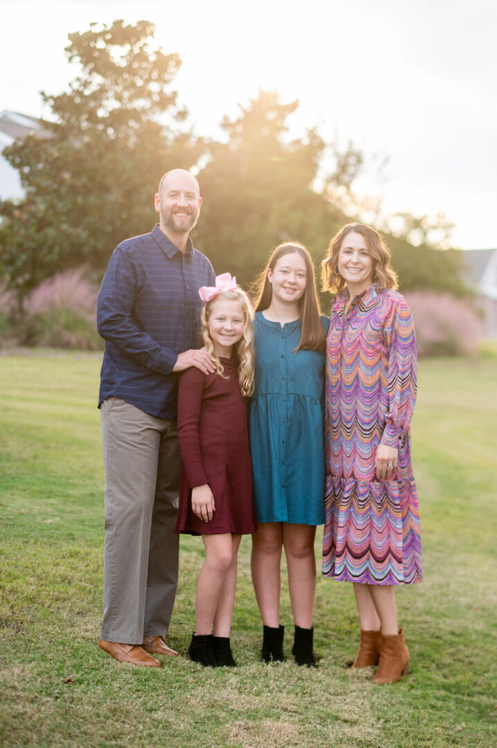 Family posing outdoors in the sunlight