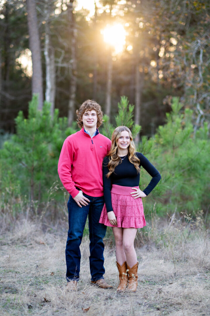 Young couple poses in forest clearing