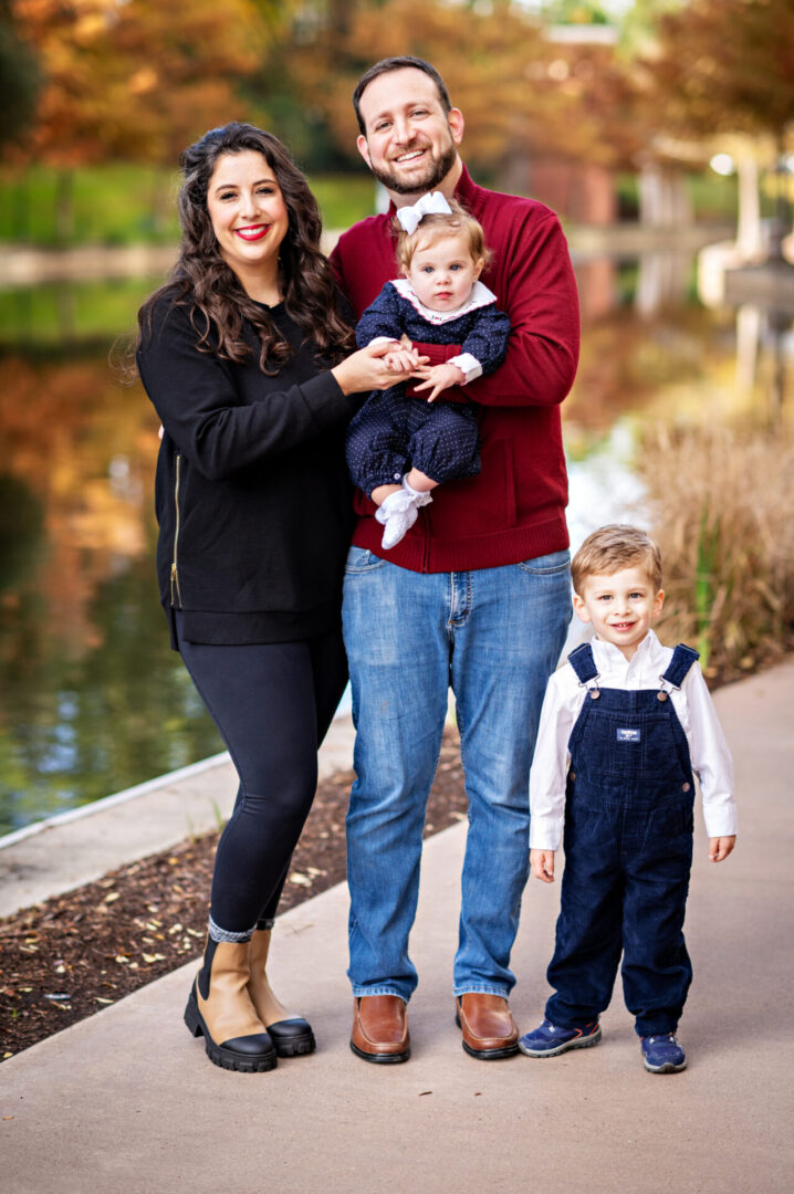Family posing by a lakeside path