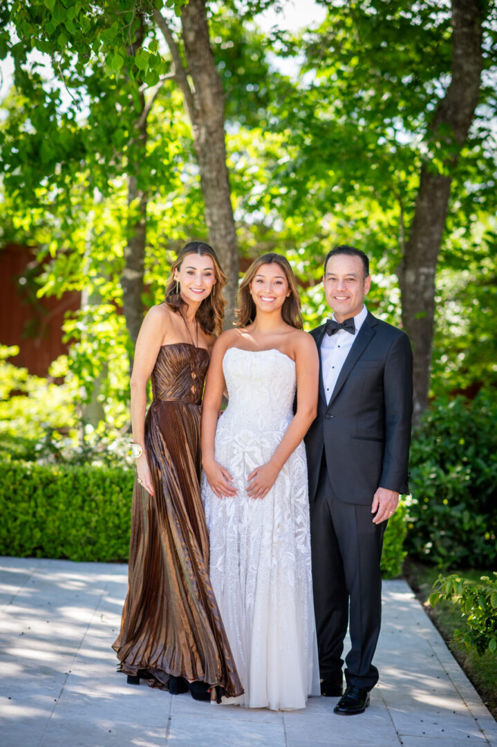 Three people in formal attire outdoors