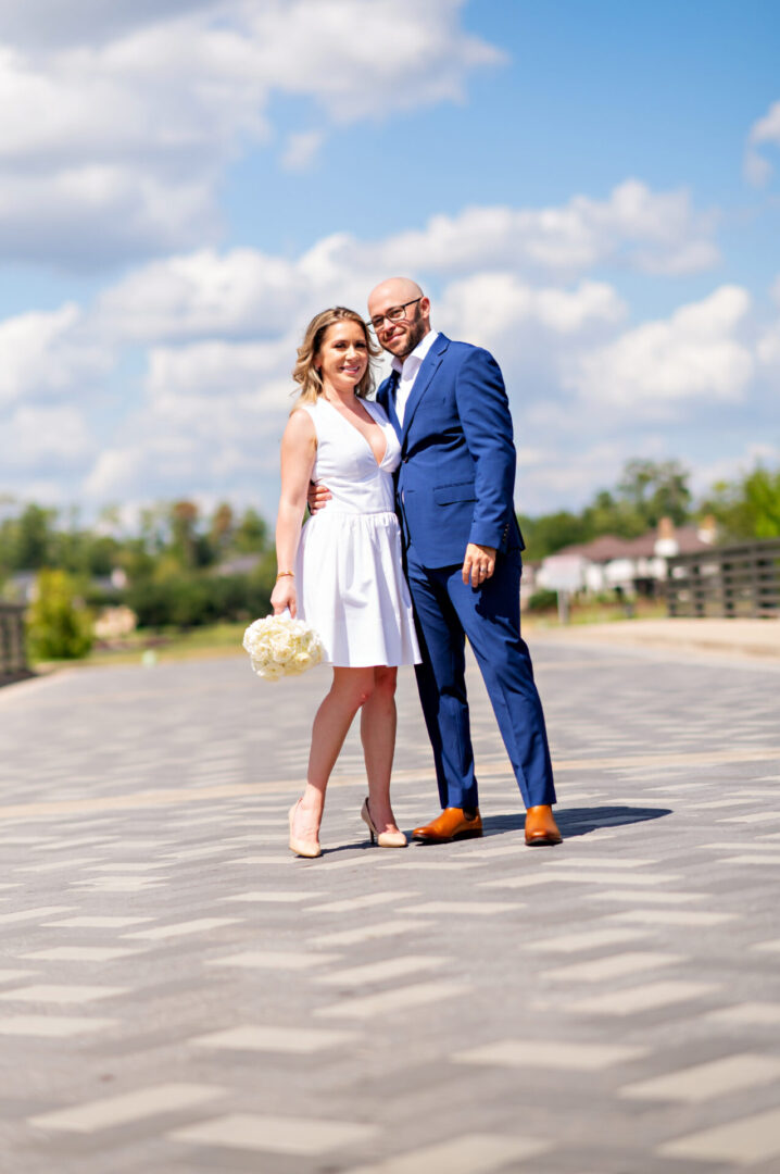 Bride holding bouquet beside groom