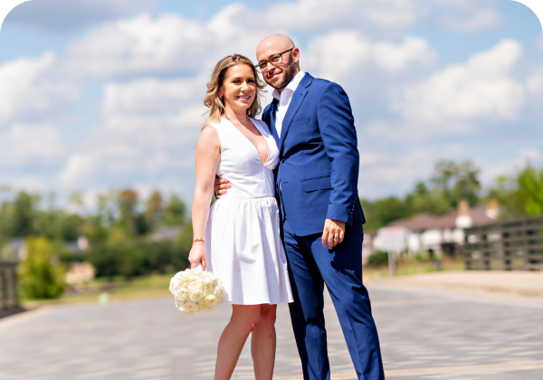 Happy couple posing outdoors in wedding attire